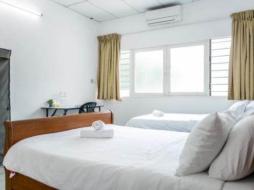 ein Schlafzimmer mit zwei Betten und einem Fenster in der Unterkunft Lodge 22, 5 min walk to Adventist & Pulau Tikus Market in George Town