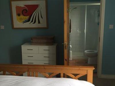 a bedroom with a bed and a bathroom with a toilet at Peaceful bliss 200 meters from the beach in Rossnowlagh