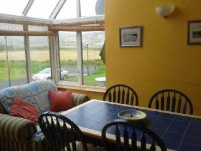 a living room with a table and chairs and a couch at Peaceful bliss 200 meters from the beach in Rossnowlagh