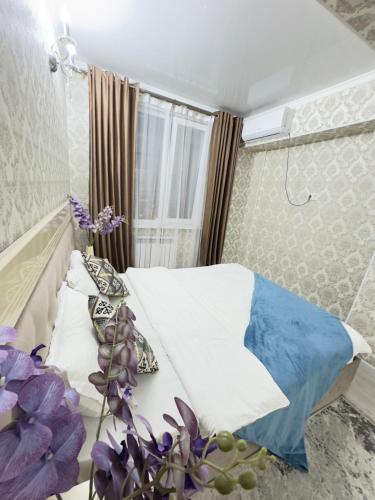 a small bedroom with a bed and a window at Your Home Away from Home 213 in Almaty