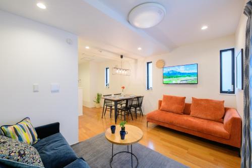 a living room with a couch and a table at Sangen-jaya House-O in Tokyo