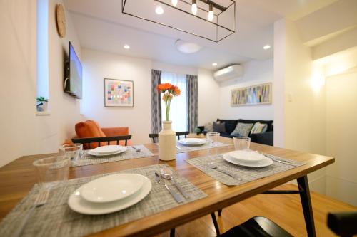 a dining room with a table and a living room at Sangen-jaya House-O in Tokyo
