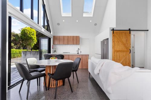 a kitchen and dining room with a table and chairs at Estuary Views - Riverhead Holiday House in Auckland