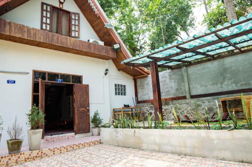 an external view of a house with a wooden door at La Cabina - Charming quiet house - Free Motobike in Luang Prabang