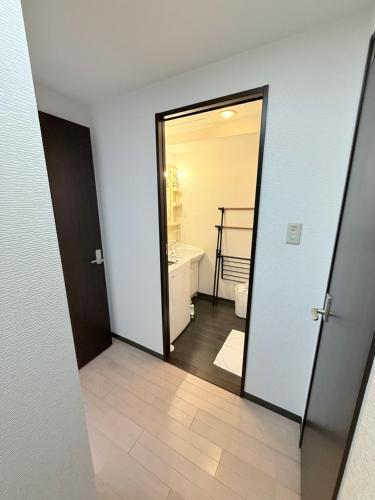 an open door to a bathroom with a mirror at Sun Court Heiwa-dori 801 in Tsukisappu