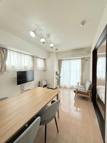 a living room with a wooden table and chairs at Sun Court Heiwa-dori 801 in Tsukisappu