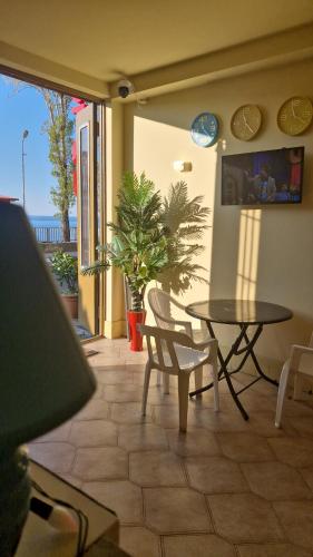 un patio con tavolo, sedie e piante di FOX Orbi Resort Hotel a Itʼkhvisi