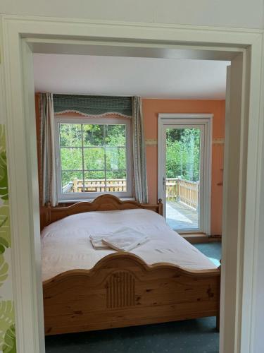 a bedroom with a wooden bed and a window at Villa Skogsro with a Large Plot in Southern Sweden in Abbetorp