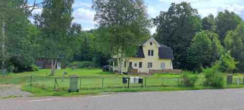 a yellow house with a black roof on a yard at Villa Skogsro with a Large Plot in Southern Sweden in Abbetorp