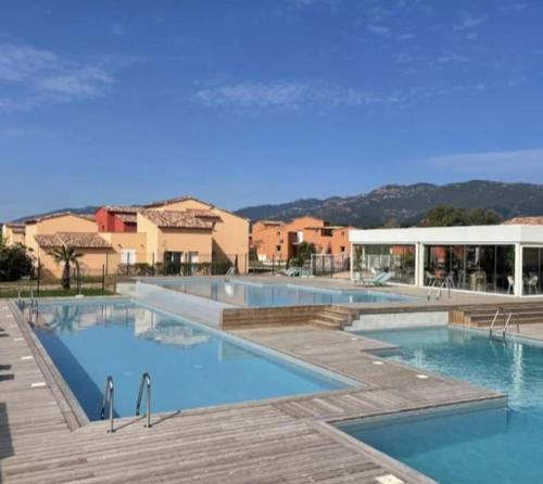 - une grande piscine d'eau bleue et des bâtiments dans l'établissement T2 avec piscines dans résidence hôtelière à Lecci, à Lecci