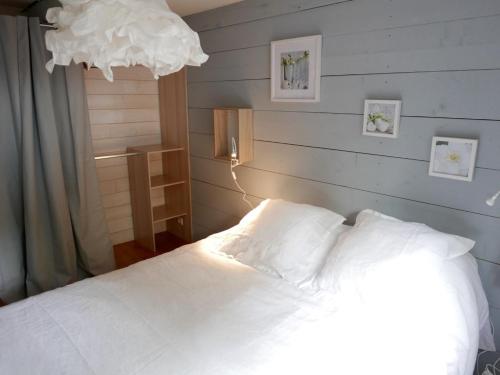 ein Schlafzimmer mit einem Bett mit weißen Laken und einer Lampe in der Unterkunft Gite en plein coeur de la Lozère Chalet 2 in Banassac