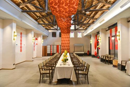 a large banquet hall with a long table with chairs at Dak Han Mansion Guangzhou in Guangzhou