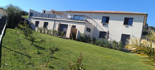 a white house on a hill with a yard at Doume et Coco T1 30M2 Vue mer in Taglio-Isolaccio