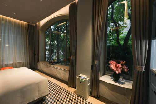 a bedroom with a bed and a window with flowers at Dak Han Mansion Guangzhou in Guangzhou