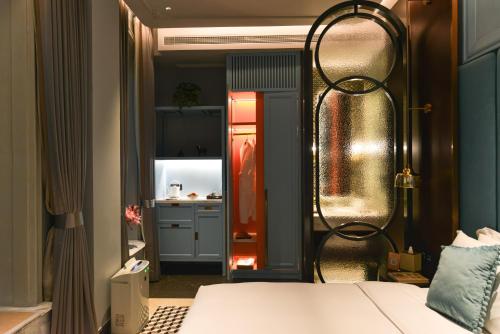 a bedroom with a bed and a kitchen in the background at Dak Han Mansion Guangzhou in Guangzhou