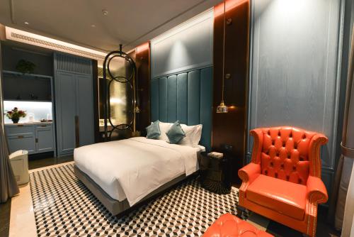 a bedroom with a bed and a red chair at Dak Han Mansion Guangzhou in Guangzhou
