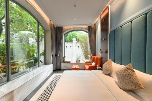a bedroom with a large bed and a window at Dak Han Mansion Guangzhou in Guangzhou