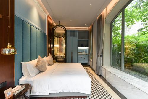 a bedroom with a bed and a large window at Dak Han Mansion Guangzhou in Guangzhou
