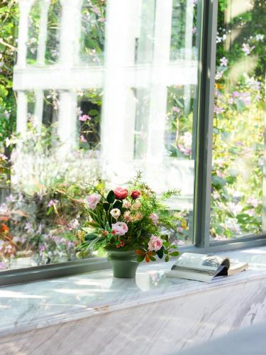 a vase of flowers sitting on a window sill with a book at Dak Han Mansion Guangzhou in Guangzhou