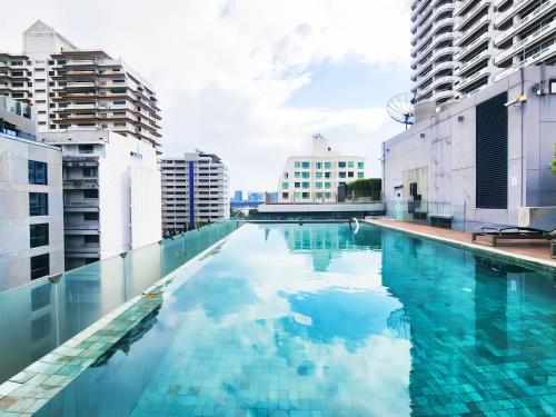 a swimming pool in a city with tall buildings at Circle S Sukhumvit 12 Bangkok in Bangkok