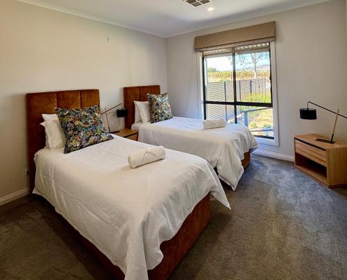 two beds in a room with a window at Pirathon Country Estate in Tanunda