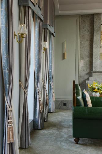 a row of curtains in a room with a green couch at Dak Han Mansion Guangzhou in Guangzhou