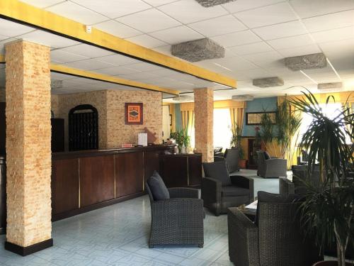 uma sala de espera com cadeiras e uma recepção em Hotel Don Pedro em Portoscuso