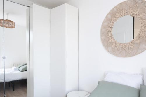 - une chambre blanche avec un miroir et un lit dans l'établissement T2 of 22m2 with balcony in Aubervilliers, à Aubervilliers