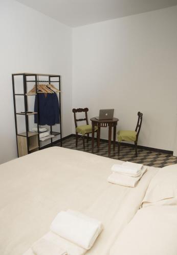 a room with a bed with two chairs and a table with a laptop at Ca' Mati in Imperia