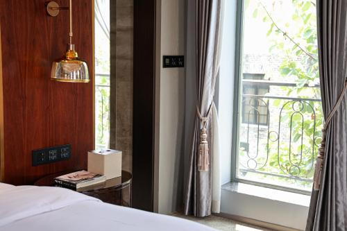 a bedroom with a bed and a large window at Dak Han Mansion Guangzhou in Guangzhou