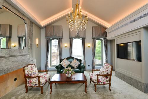 a living room with a couch and chairs and a chandelier at Dak Han Mansion Guangzhou in Guangzhou