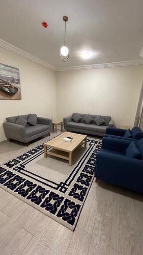 a living room with two couches and a coffee table at فندق فاتوران فرع ينبع in Yanbu