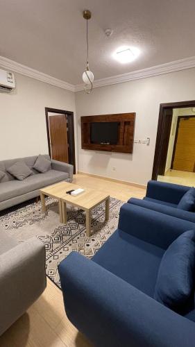 a living room with blue couches and a table at فندق فاتوران فرع ينبع in Yanbu