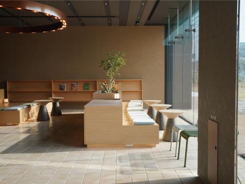 a lobby with benches and a table and a plant at Dorsett by Agora Osaka Sakai in Sakai