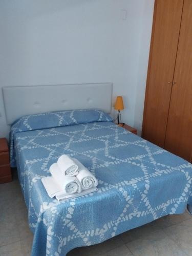 a bedroom with a blue bed with towels on it at Apartamento Maru's in Oropesa del Mar