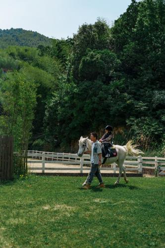 a boy walking a horse with a child on it at AHN LAN Ninghai in Ninghai