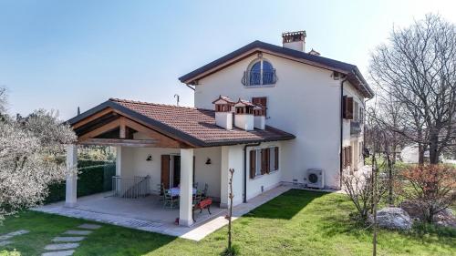 a white house with a roof and a yard at Alloggio romantico nel verde in fronte Acquardens in SantʼAmbrogio di Valpolicella