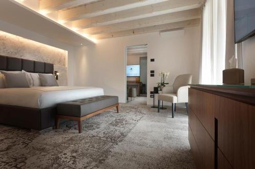 a bedroom with a large bed and a television at Ca' Apollonio Heritage in Romano D'Ezzelino