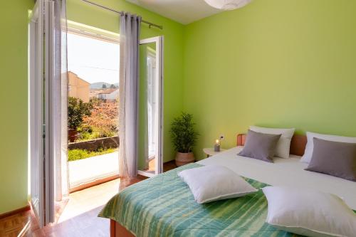 a bedroom with a large bed and a large window at Naša kuća in Vela Luka