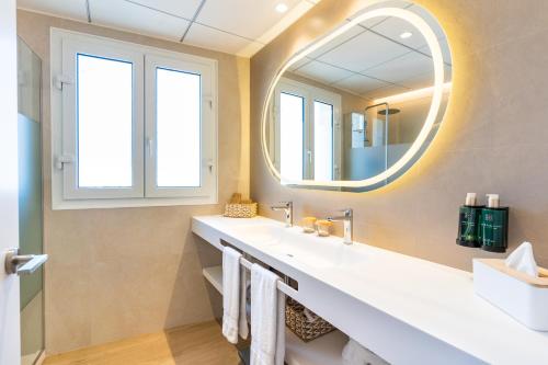 a bathroom with a sink and a mirror at Melia Plaza Valencia in Valencia