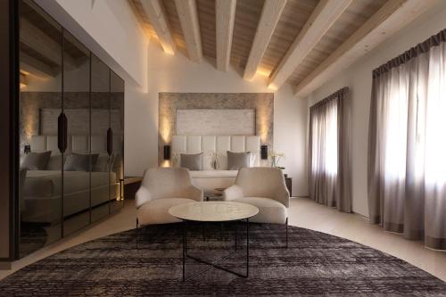 a hotel room with a bed and a table and chairs at Ca' Apollonio Heritage in Romano D'Ezzelino