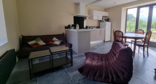 un salon avec un canapé et une table dans l'établissement Les Marthalice, à Brégnier-Cordon
