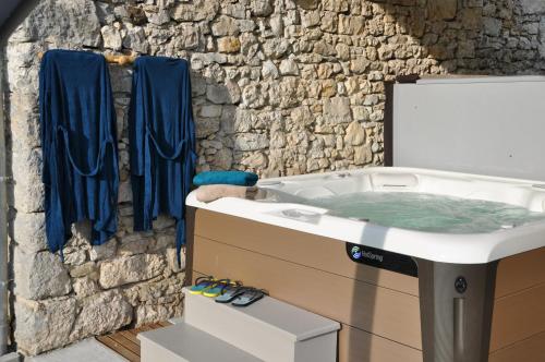 La salle de bains est pourvue d'une baignoire et d'un mur en pierre. dans l'établissement Les Marthalice, à Brégnier-Cordon