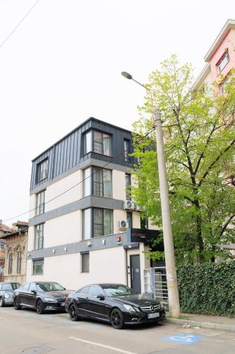 two cars parked in front of a building at The Embassy Nord in Bucharest
