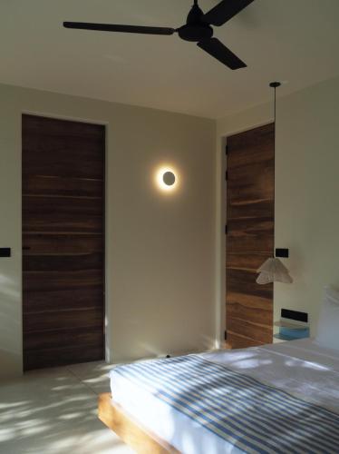 a bedroom with a bed and a ceiling fan at Sola - Boutique Hotel in Ahangama