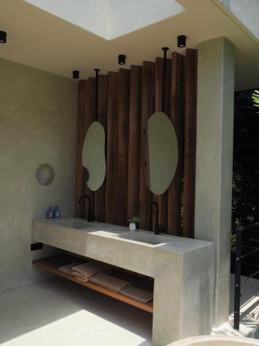 a bathroom with two sinks and two mirrors at Sola - Boutique Hotel in Ahangama