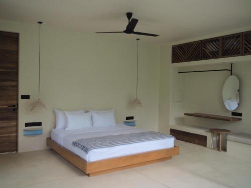 a bedroom with a bed with a ceiling fan at Sola - Boutique Hotel in Ahangama