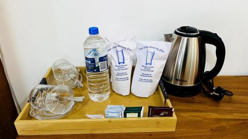 a wooden tray with two bottles of water and glasses at EllaCrest by Aloft in Kumbalwela
