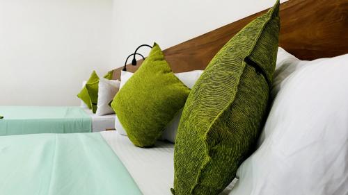a group of green pillows on a bed at EllaCrest by Aloft in Kumbalwela