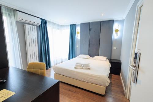 a hotel room with a bed and a desk and a table at The Embassy Nord in Bucharest